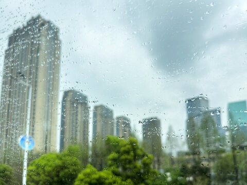 Rain speckled window with blurred high rise skyline in a China city