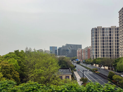 Urban avenue and apartment towers in Hangzhou under overcast sky, China