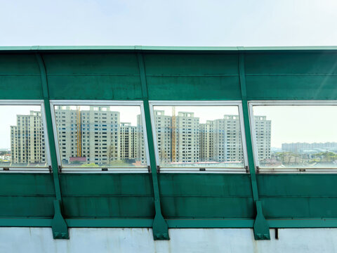 Urban apartment towers viewed through green elevated road windows in Pudong Shanghai, China