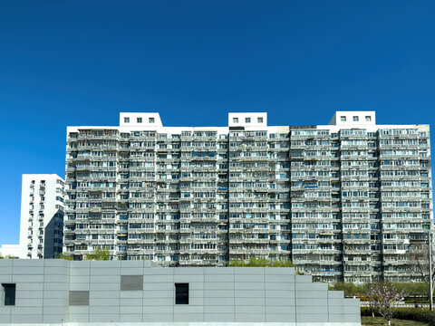 Dense high rise apartment facade under clear blue sky in Beijing, China