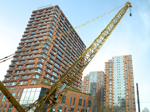 Yellow tower crane beside modern residential high rise buildings in Beijing China