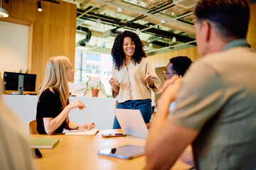 Multicultural business professional leading a team meeting, discussing ideas and collaborating in a...