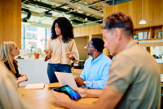 Diverse business team collaborating and exchanging ideas in a modern office meeting. Professionals brainstorm new project concepts