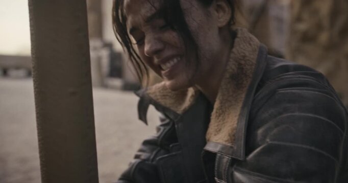 Closeup of dirty, female adventurer trying to free herself and talking to someone off screen