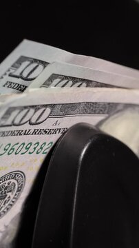 Money counting machine. Currency counting machine counting US money. Slow Motion, vertical video.