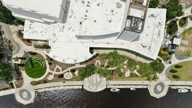 Aerial view of Riverfront Plaza featuring modern architecture, winding pedestrian paths, and a treble clef design along the riverbank in Jacksonville, Florida, United States.