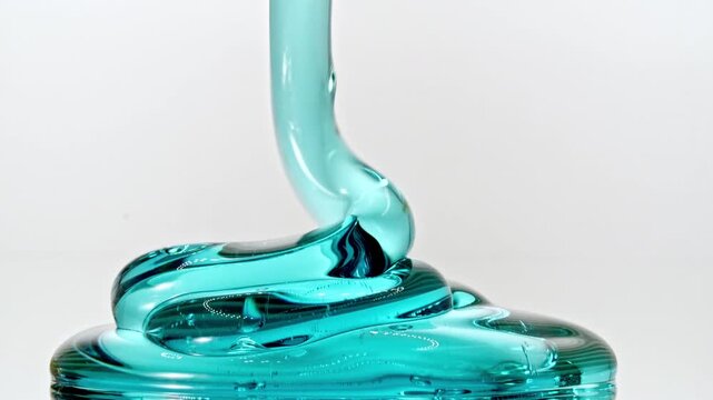 Transparent Gel, Fluid, Serum, Essential Oil Pours from Above on a White Glas Surface. Macro Shot of Natural Organic Cosmetics, Medicine. Skin or Body Care Products. Advertising Background. 4k 