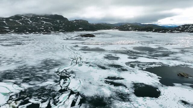 Aerial of a frozen lake and rugged landscape of Norway.