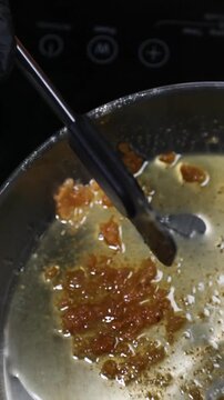 Chef derritiendo grasa de jam&oacute;n ib&eacute;rico en sart&eacute;n de acero inoxidable. Chef profesional cocinando grasa de jam&oacute;n en sart&eacute;n de acero. Cocina tradicional espa&ntilde;ola, proceso de cocina artesanal.