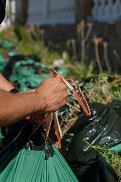 Vertical close up of man closing bag with garden waste