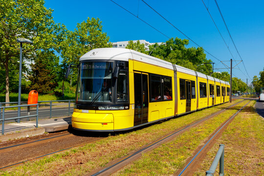 Moderne Tram der Linie M17 in Berlin an der Haltestelle Criegernweg. Berliner Nahverkehr in gr&uuml;ner Umgebung im Bezirk Lichtenberg / Friedrichsfelde am fr&uuml;hen Morgen