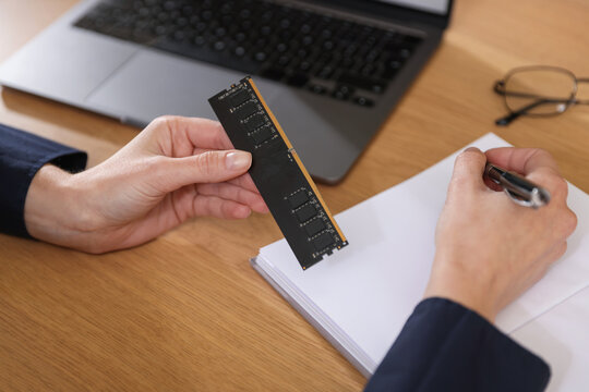 Woman with SD RAM working at wooden desk, closeup