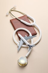 Obraz premium Medical tourism. Passport, stethoscope and plane model on beige background, flat lay