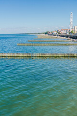 Obraz premium Turquoise Sea with Wooden Breakwaters Coastal Town