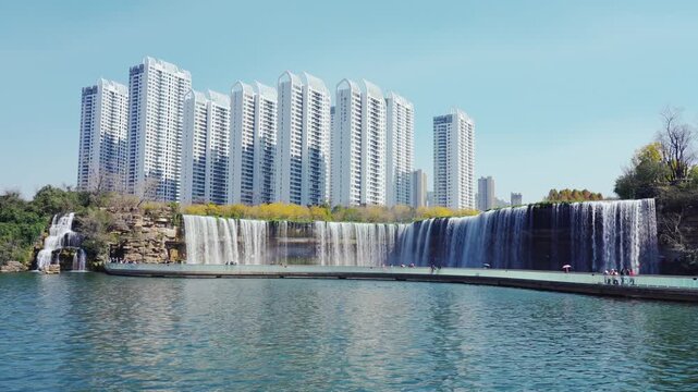 Modern high rise apartments beside urban waterfall and waterfront walkway