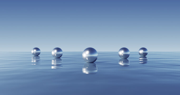 Conjunto minimalista de esferas met&aacute;licas que se reflejan en aguas azules cristalinas con un cielo infinito.
