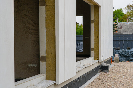 Prefab modular house wall detail with exposed insulation layer around large window openings facade