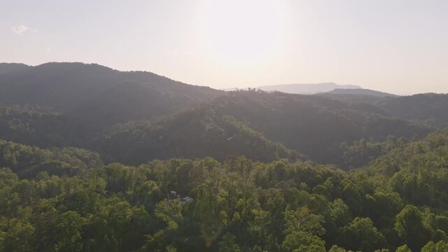 Dark silhouette of large mountains, hills, and terrain of Smoky Mountains in distance from Gatlinburg and Pigeon Forge in moody lighting with trees, forest, wildlife, mountain range, and drone aerial