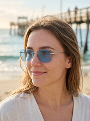 Obraz premium Portrait of a stylish woman with sunglasses on the beach
