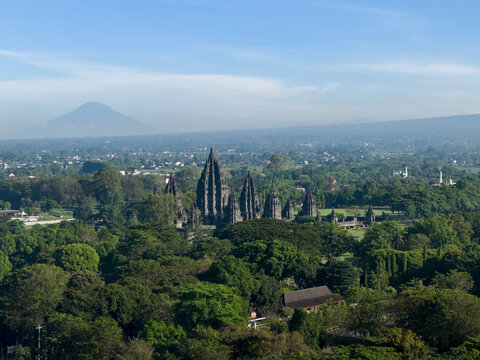 Aerial view of Prambanan Temple complex surrounded by lush tropical forest with Mount Merapi volcano in the background Kecamatan Prambanan, Daerah Istimewa Yogya, Indonesia.