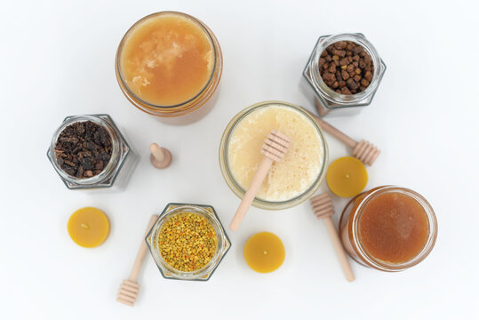 Assortment of honey jars and bee products on white background