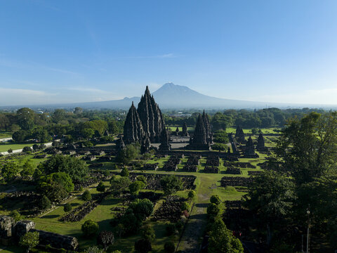 Aerial view of Prambanan Temple complex with its towering stone spires set against the backdrop of Mount Merapi and lush tropical greenery Kecamatan Prambanan, Daerah Istimewa Yogya, Indonesia.