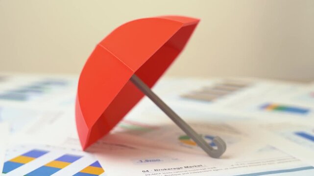 A red insurance umbrella is on the reports and charts. Insurance services. Protection and security. Compensation for damages. Modern coverage plans reduce risk and give families confidence