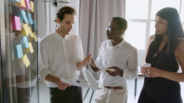 Colleagues meet in an office to brainstorm ideas using sticky notes. They share thoughts, discuss plans, and enjoy each other's input throughout the session