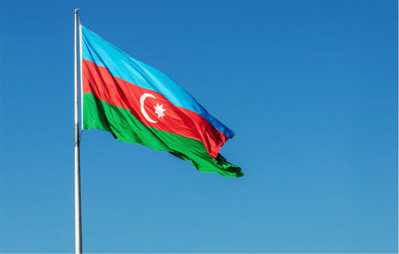 The azerbaijani flag waves on a flagpole against a clear blue sky