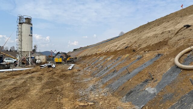 Construction of railway line LK104 with advanced ground stabilization and engineering structures. Geotechnical works including pile walls, soil reinforcement, ground nails, and slope protection system