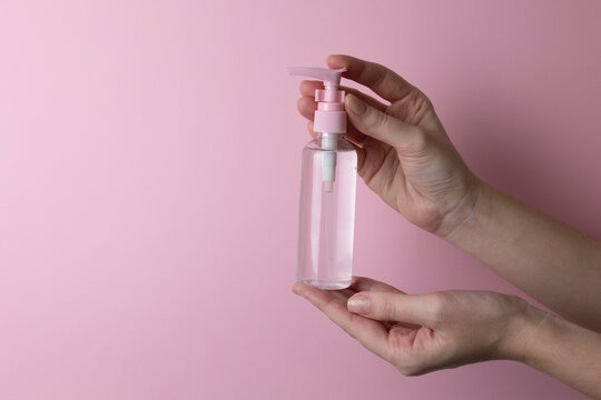 intimate lubricant in hands on colored background