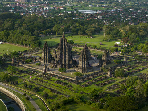 Aerial view of the ancient Prambanan Temple complex featuring towering stone spires surrounded by lush green parkland in Kecamatan Prambanan, Daerah Istimewa Yogya, Indonesia.