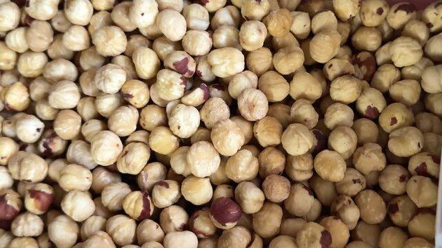 Raw peeled and whole hazelnuts in shells displayed in containers with rich natural texture and nutritious food concept for healthy eating and market sale.