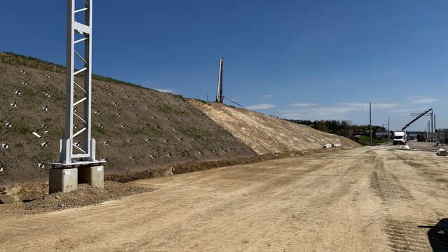 Construction of railway line LK104 with advanced ground stabilization and engineering structures. Geotechnical works including pile walls, soil reinforcement, ground nails, and slope protection system