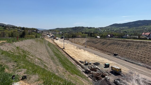 Construction of railway line LK104 with advanced ground stabilization and engineering structures. Geotechnical works including pile walls, soil reinforcement, ground nails, and slope protection system