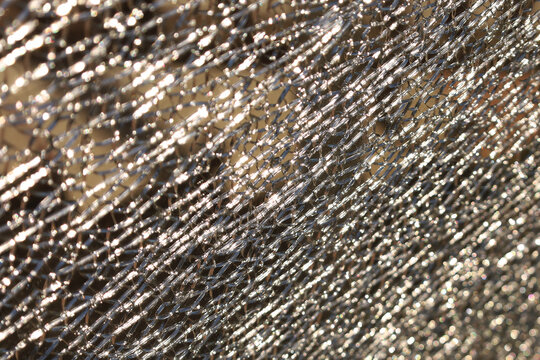 Metal surface gleams under sunlight, showing diagonal scratches