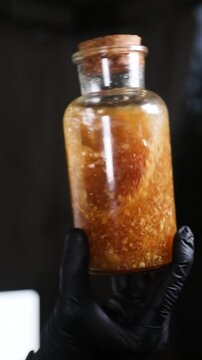 Chef agitando un frasco de ron con avellanas para una receta de c&oacute;ctel moderno. Un chef profesional mezcla ron y avellanas en un frasco. Preparaci&oacute;n de c&oacute;ctel moderno, receta culinaria innovadora.