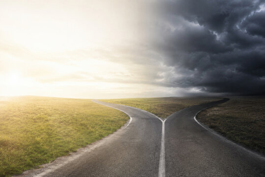 Road splits between bright and stormy landscapes. Space for text.