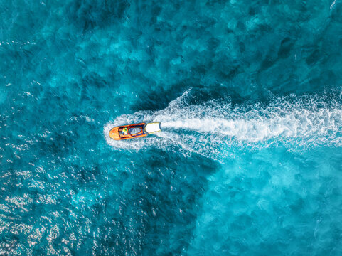 Aerial drone view of beautiful floating boat in blue sea on sunny day in summer. Mallorca island, Spain. Top down view of boat, sea, turquoise water. Travel. Tropical landscape. Yachting. Cruise