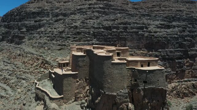 Ancient Earthen Fortress Perched on Rocky Cliff Face

