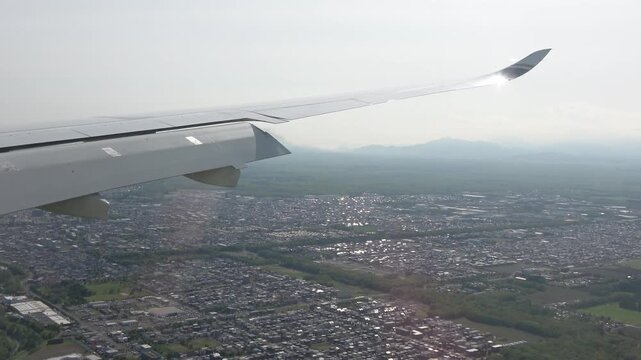 Window view: the airplane preparing for landing, with inboard flaps creating aerodynamic wakes.