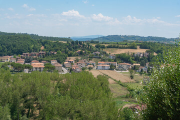 Fototapeta premium Tuscan rural landscape featuring traditional houses among wooded hills. Authentic regional scenery of Certaldo, Italy