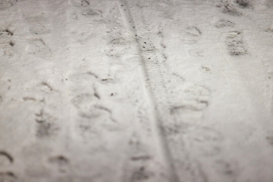 Winter boot footprints in fresh snow on sidewalk as evidence