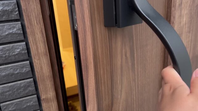 玄関ドアを開けて家に入る手元