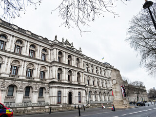 Naklejka premium Historic Foreign, Commonwealth and Development Office government building facade on wide street in central London UK with memorial column