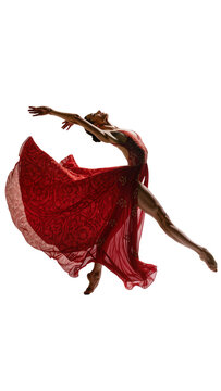 Isolated elegant female ballet dancer in red flowing dress leaping gracefully mid-air