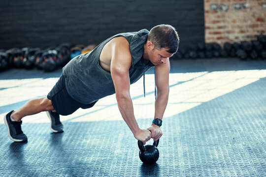 Man, push up and kettlebell for fitness at gym with exercise, muscle development or power on floor. Person, bodybuilder and training equipment for challenge, strong and workout with weights at club