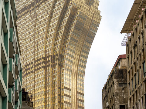 Macau, China, 4 March 2026: futuristic golden Grand Lisboa tower rising above old urban buildings in the historic center of Macau