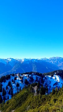 Stunning aerial view of the Carnic Alps surrounding Tolmezzo, Italy. The majestic Monte Amariana peak towers over the Tagliamento valley in a scenic winter panorama of the Friuli-Venezia Giulia region