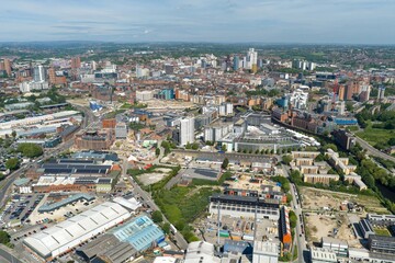 Obraz premium Detailed aerial drone view of Leeds city centre in West Yorkshire UK showing modern skyscrapers commercial districts and urban redevelopment beneath a bright blue sky in the summer time